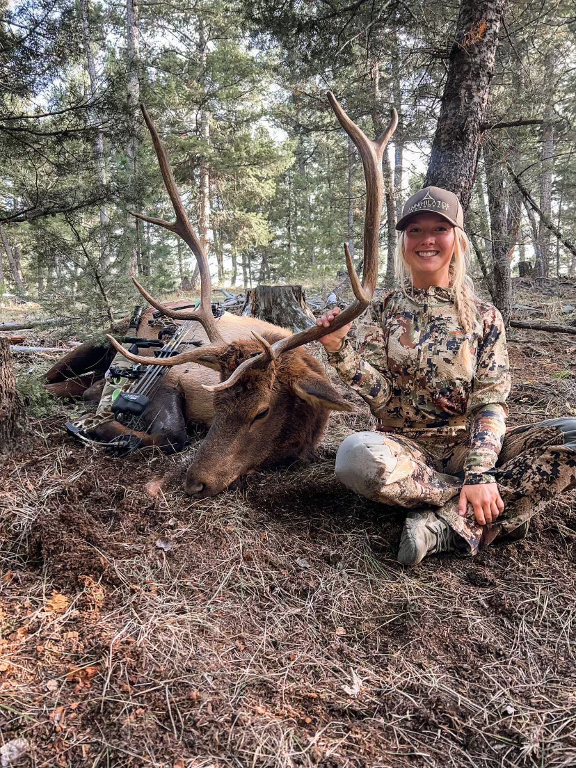 girl in camouflage with a deer hunted with crossbow
