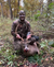 camouflaged man displays a deer after hunting